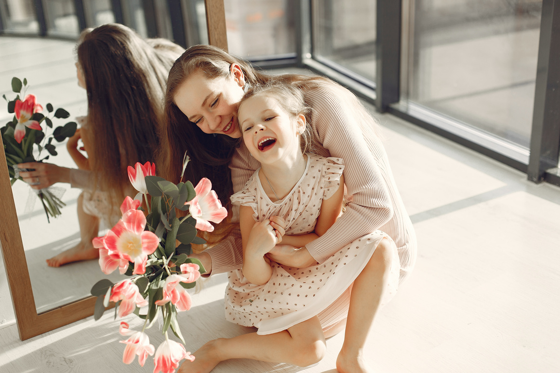 Photo of Mother and Daughter Sitting on the Floor